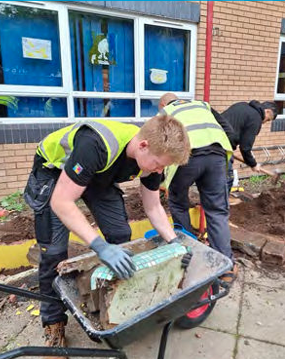 Three people working outside to rebuild a garden