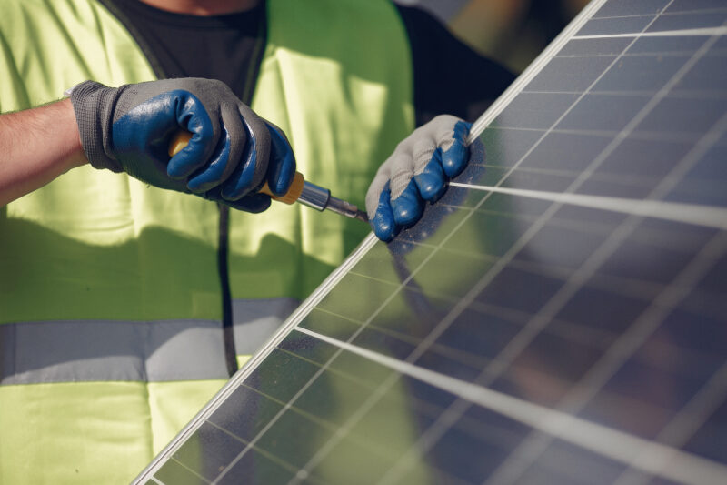 Engineer near solar panel holding tools.