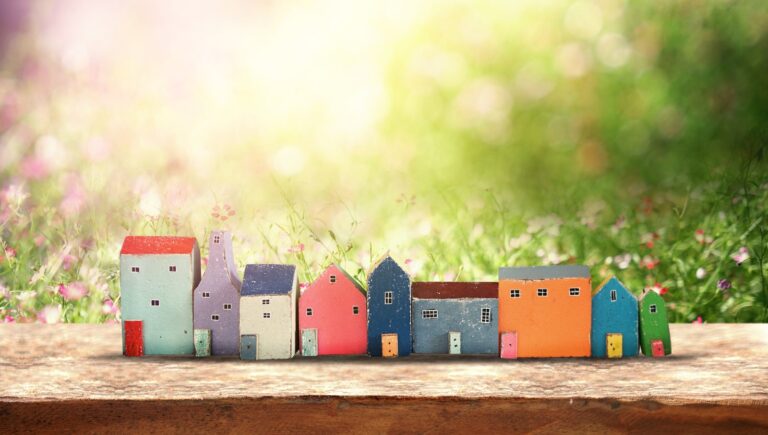 A row of small painted wooden model houses in different colours