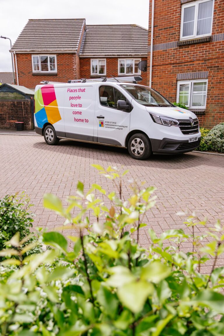 A Cornerstone repairs van parked outside a row of homes