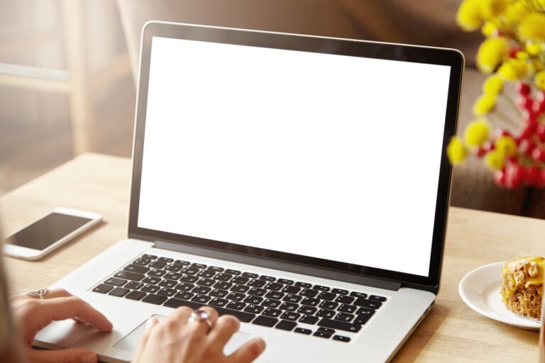 A person using a laptop at a table to report a repair online