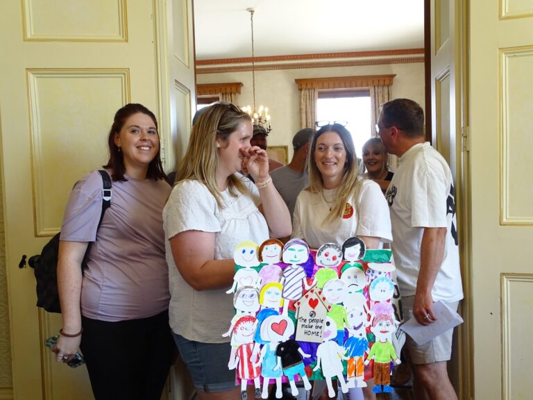 Colleagues standing with a display of paper figures decorated by children