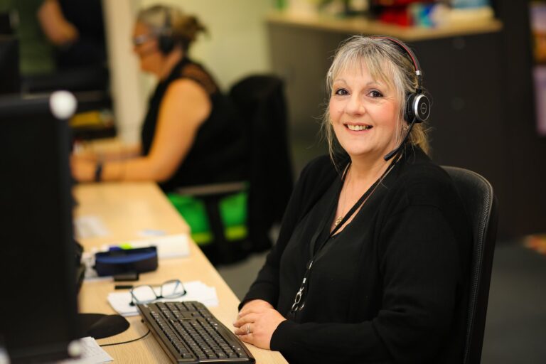 A Cornerstone colleague wearing a headset at her desk