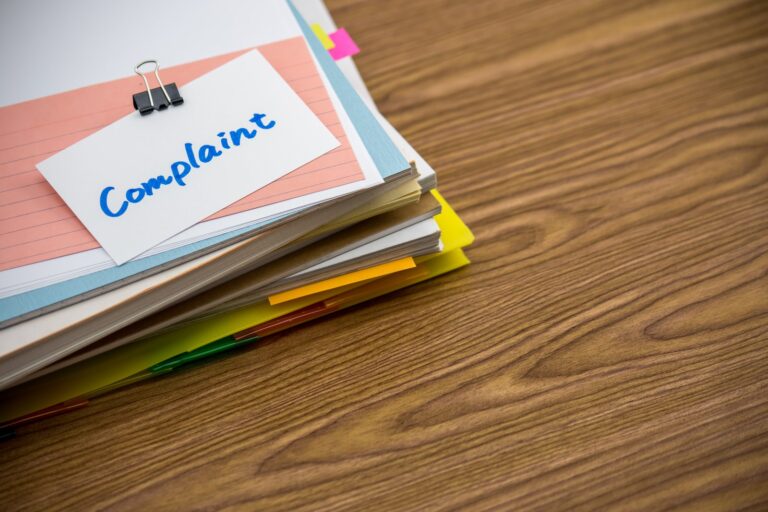 A handwritten note reading Complaint clipped to a stack of papers