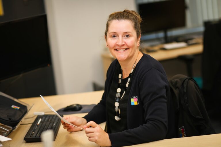 A Cornerstone colleague working at her desk with paperwork in hand