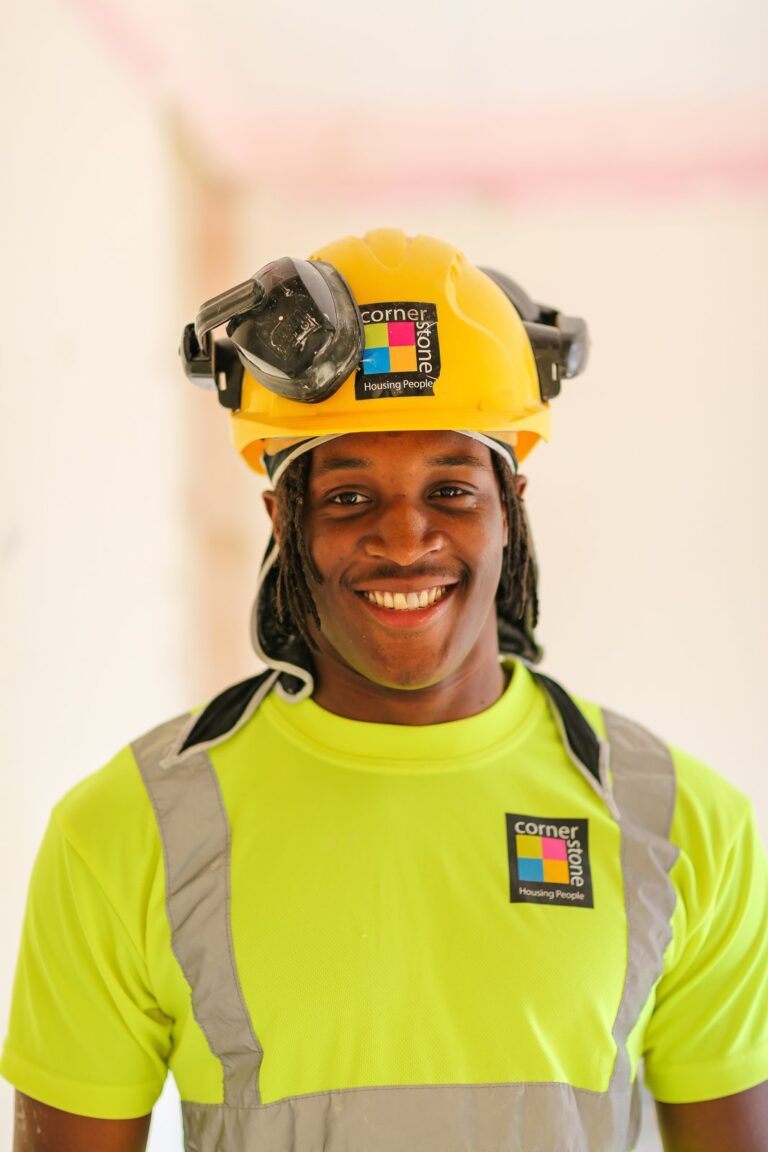 A Cornerstone operative in a yellow hard hat and hi-vis top, smiling
